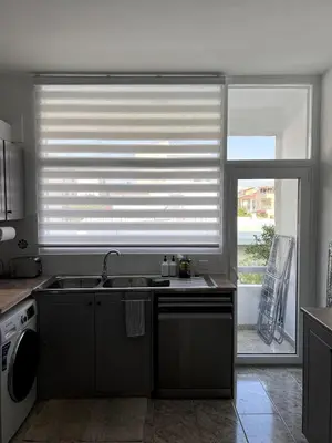 a kitchen with a sink and a window with a blind at Casi-Homes in Larnaka