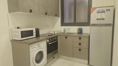 a kitchen with a microwave and a washing machine at STAY Finibreeze Apartment in Larnaka