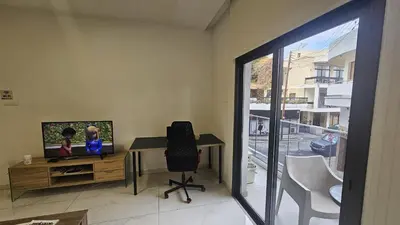 a room with a desk with a television and a chair at STAY Finibreeze Apartment in Larnaka