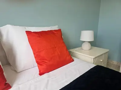 a red pillow sitting on top of a bed at Kapparis - Blue and aqua in Paralimni