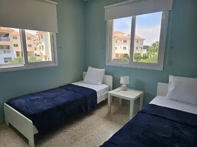 two beds in a room with two windows at Kapparis - Blue and aqua in Paralimni