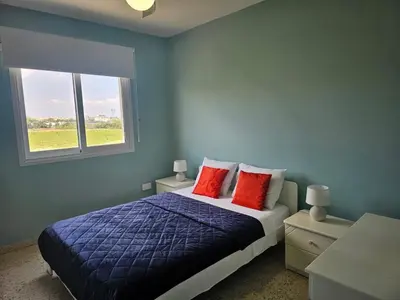 a bedroom with a bed with red pillows and a window at Kapparis - Blue and aqua in Paralimni