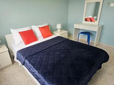 a bedroom with a bed with red pillows and a mirror at Kapparis - Blue and aqua in Paralimni