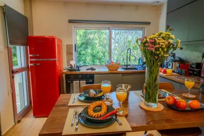 a kitchen with a wooden table with food and a red refrigerator at 1 BDR New Boutique & Prime Location in Limassol