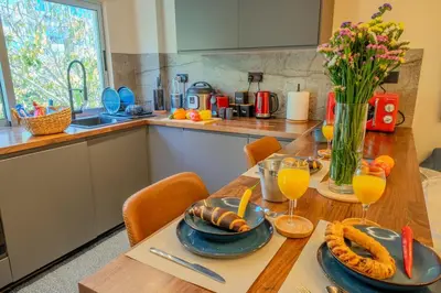 a kitchen with a wooden table with food and drinks at 1 BDR New Boutique & Prime Location in Limassol