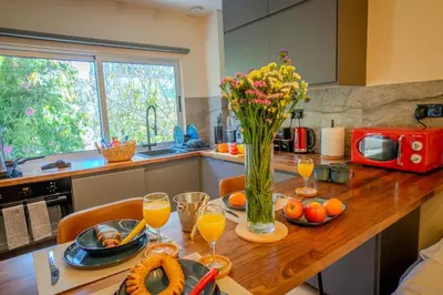 a kitchen with a wooden table with a vase of flowers at 1 BDR New Boutique & Prime Location in Limassol