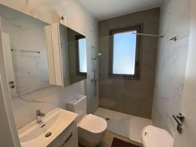 a white bathroom with a sink and a toilet at 1 bedroom 104 in Limassol