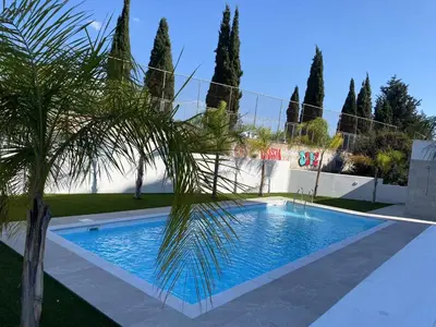 a palm tree in front of a swimming pool at 1 bedroom 104 in Limassol