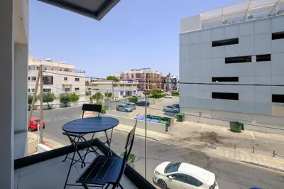 a table and chairs on a balcony with a view of a street at Majan Residences in Larnaka