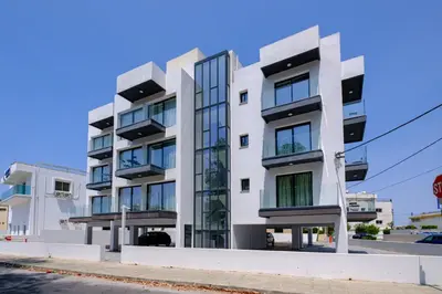 a white building with glass windows on a street at Majan Residences in Larnaka
