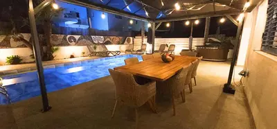 a dining room with a table and a swimming pool at Villa Elia Blue , hot tube , heated pool in Paralimni