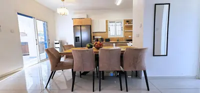 a kitchen with a dining room table and chairs at Villa Elia Blue , hot tube , heated pool in Paralimni