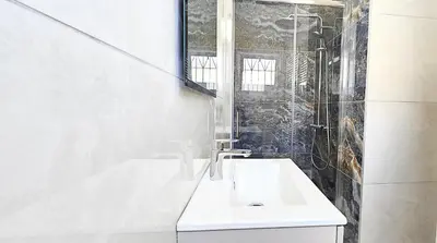 a white bathroom with a sink and a shower at Villa Elia Blue , hot tube , heated pool in Paralimni