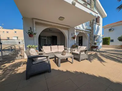 a patio with wicker chairs and tables on a building at Fig Tree Bay Villa Elena in Protaras