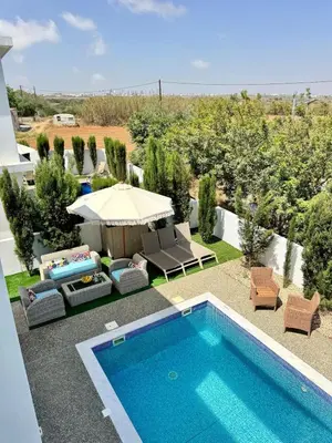 a backyard with a swimming pool and an umbrella at Villa Jarvis Modern and Quiet 3BR with Private Swimming Pool in Paralimni