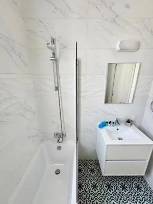 a white bathroom with a tub and a sink at Villa Jarvis Modern and Quiet 3BR with Private Swimming Pool in Paralimni