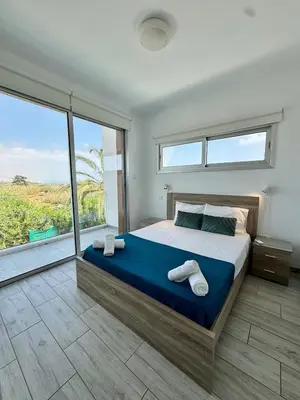 a bedroom with a large bed and a large window at Villa Jarvis Modern and Quiet 3BR with Private Swimming Pool in Paralimni