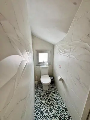 a bathroom with a white toilet and a window at Villa Jarvis Modern and Quiet 3BR with Private Swimming Pool in Paralimni