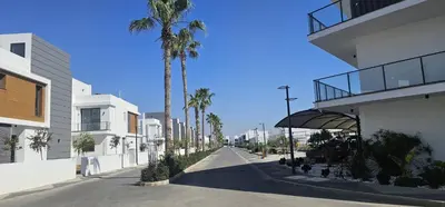 an empty street with palm trees and a building at Modern Luxury Apartment in Aglantzia
