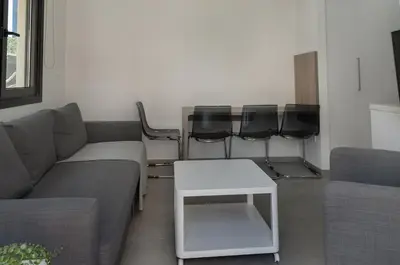 a living room with a couch and a table and chairs at Seabreeze Residence by Staycom in Larnaka