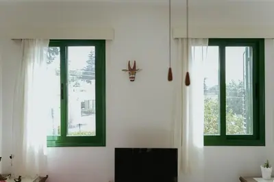 a room with two windows and a clock on the wall at Mediterraneo 27 - Protaras in Protaras