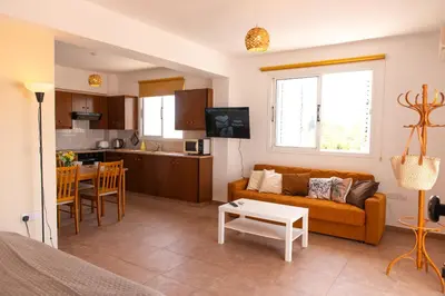 a living room with a couch and a kitchen at STAY Kali Sun Apartment in Paralimni