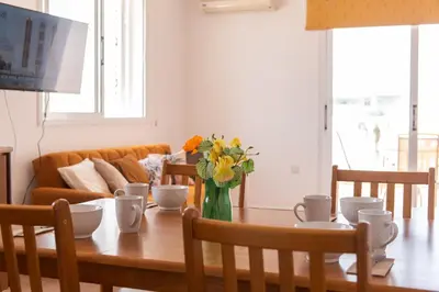 a dining room table with a vase of flowers on it at STAY Kali Sun Apartment in Paralimni