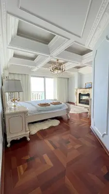 a large bedroom with a large bed and a chandelier at Kingdom Villa with Sauna and Hamam in Kaimakli