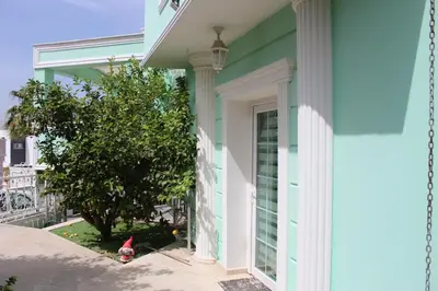 a blue house with a white door and a tree at Kingdom Villa with Sauna and Hamam in Kaimakli