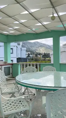 a table and chairs on a balcony with a view at Kingdom Villa with Sauna and Hamam in Kaimakli