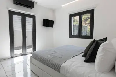 a white bedroom with a bed and two windows at Kakopetria Luxury Villa w pool in Kakopetria