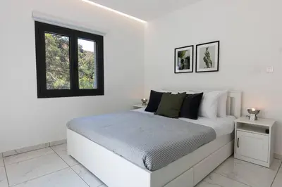 a white bedroom with a bed and a window at Kakopetria Luxury Villa w pool in Kakopetria