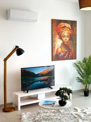 a living room with a flat screen tv on a white wall at Sunset Balcony and Espresso Station Apartment in Larnaka