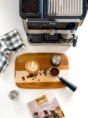a wooden cutting board with a cup of coffee and a toaster at Sunset Balcony and Espresso Station Apartment in Larnaka