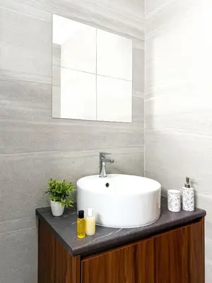 a bathroom with a white sink and a mirror at Sunset Balcony and Espresso Station Apartment in Larnaka
