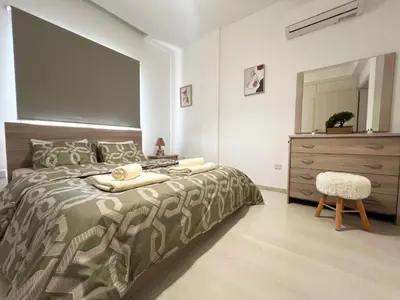a bedroom with a bed with a dresser and a mirror at Albert's Apartment Center 203B in Larnaka