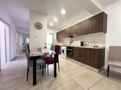 a kitchen and dining room with a table and chairs at Albert's Apartment Center 203B in Larnaka