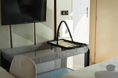 a room with a tv on a wall with a shelf at Infinity Residences in Zygi