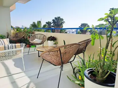 a balcony with chairs and a table and plants at Sea View Floral Suite - 2 bedroom in Larnaka