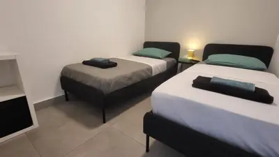 a room with two beds and a tv in it at Hanapartment 3 bed Ayia NAPA in Ayia Napa