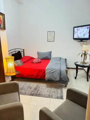 a bedroom with a red bed and a tv at 2 bedroom apartment 50 meters from the sea in Limassol