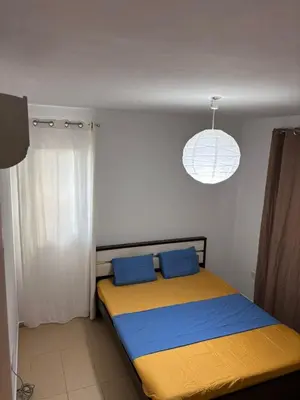 a bedroom with a bed with blue and yellow sheets at Pool flat near Ayia Napa in Sotira
