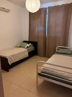 a bedroom with two beds and a chandelier at Pool flat near Ayia Napa in Sotira