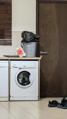 a kitchen with a washing machine and a door at Pool flat near Ayia Napa in Sotira