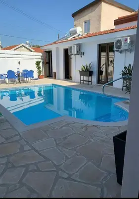 a swimming pool in front of a house at Elysian Villa in Larnaka