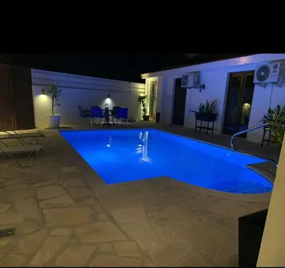 a large blue swimming pool at night at Elysian Villa in Larnaka