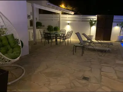 a patio with chairs and a table and chairs at Elysian Villa in Larnaka