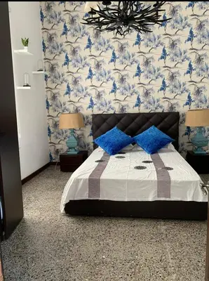 a bedroom with a bed with blue and white wallpaper at Elysian Villa in Larnaka