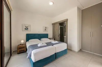 a bedroom with a large bed with a blue headboard at Ayia Napa Luxury Seaside Villa Ionion H15 in Ayia Napa
