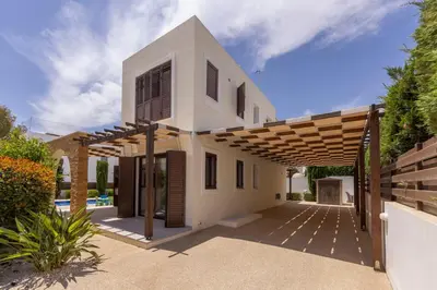 a white house with a wooden pergola at Ayia Napa Luxury Seaside Villa Ionion H15 in Ayia Napa